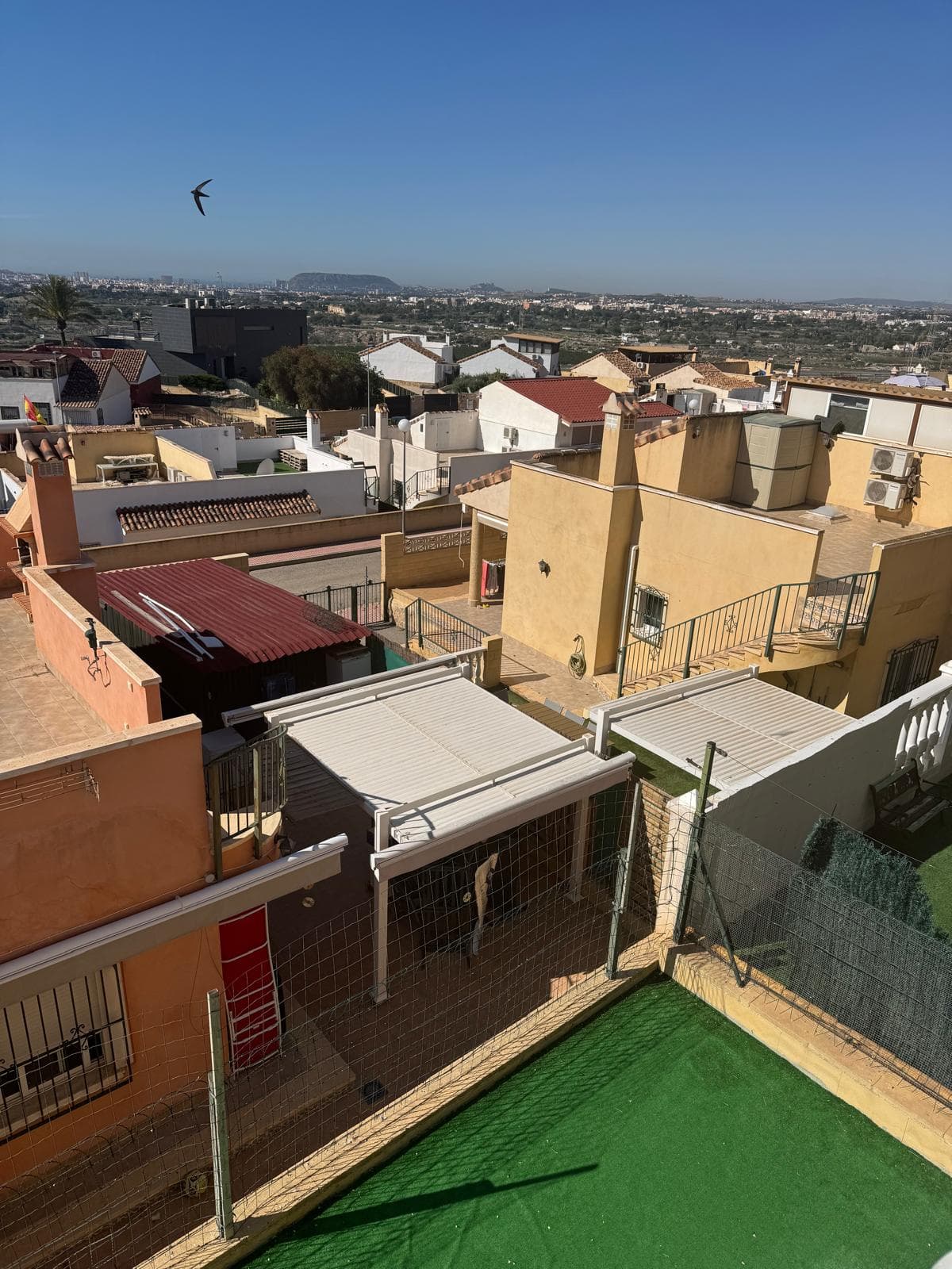 Vue depuis un balcon sur les maisons voisines et le paysage