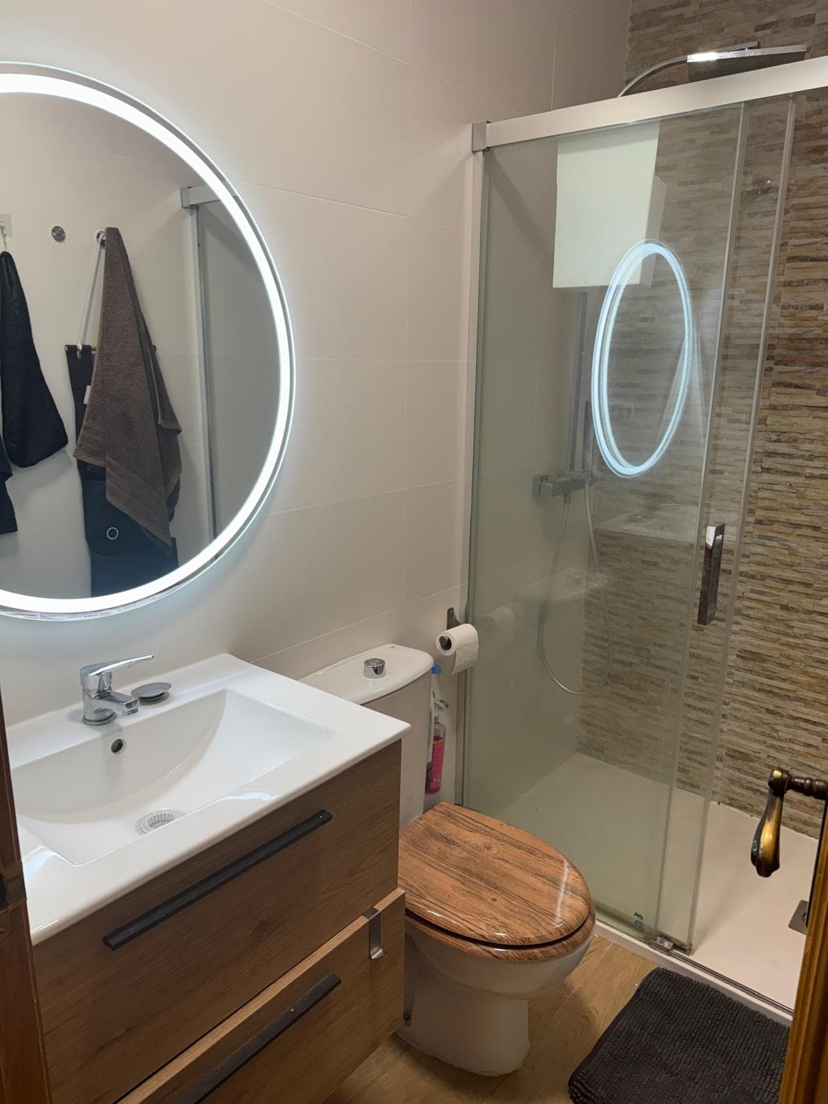 Salle de bain rénovée avec douche et miroir lumineux