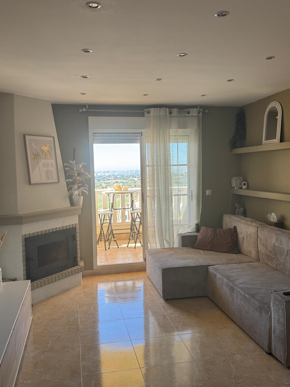 Salon avec cheminée et accès à un balcon